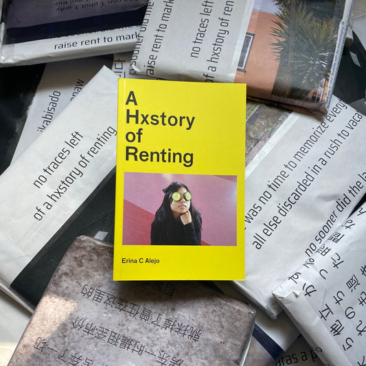 Book titled 'A History of Renting' with a yellow cover on a textured surface.